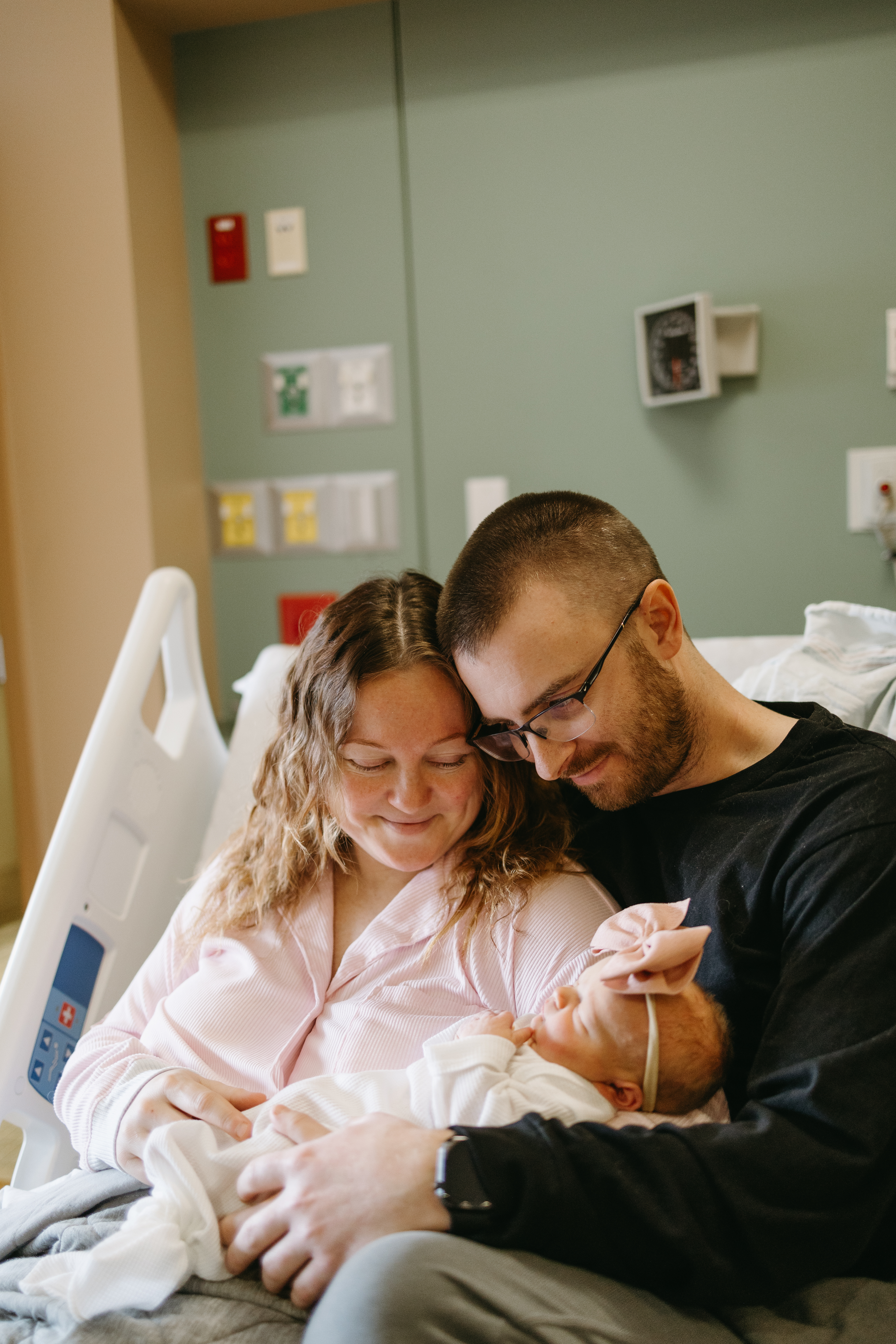 Mom, Dad and baby in the hospital bed after her birth